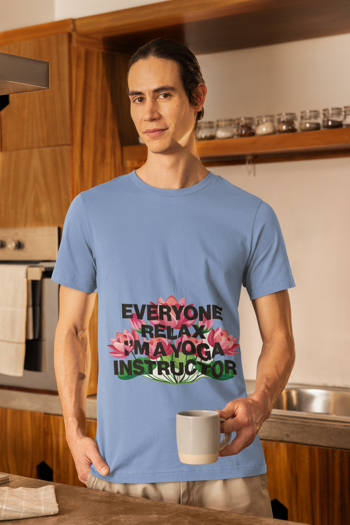 Person wearing a blue t-shirt with a yoga instructor message in a kitchen.