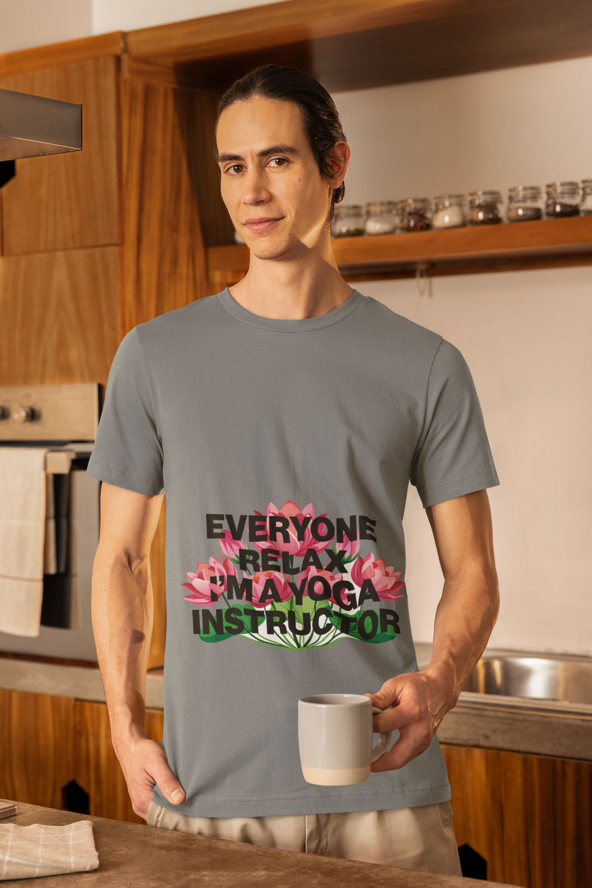Person wearing a gray t-shirt with a yoga instructor graphic in a kitchen.