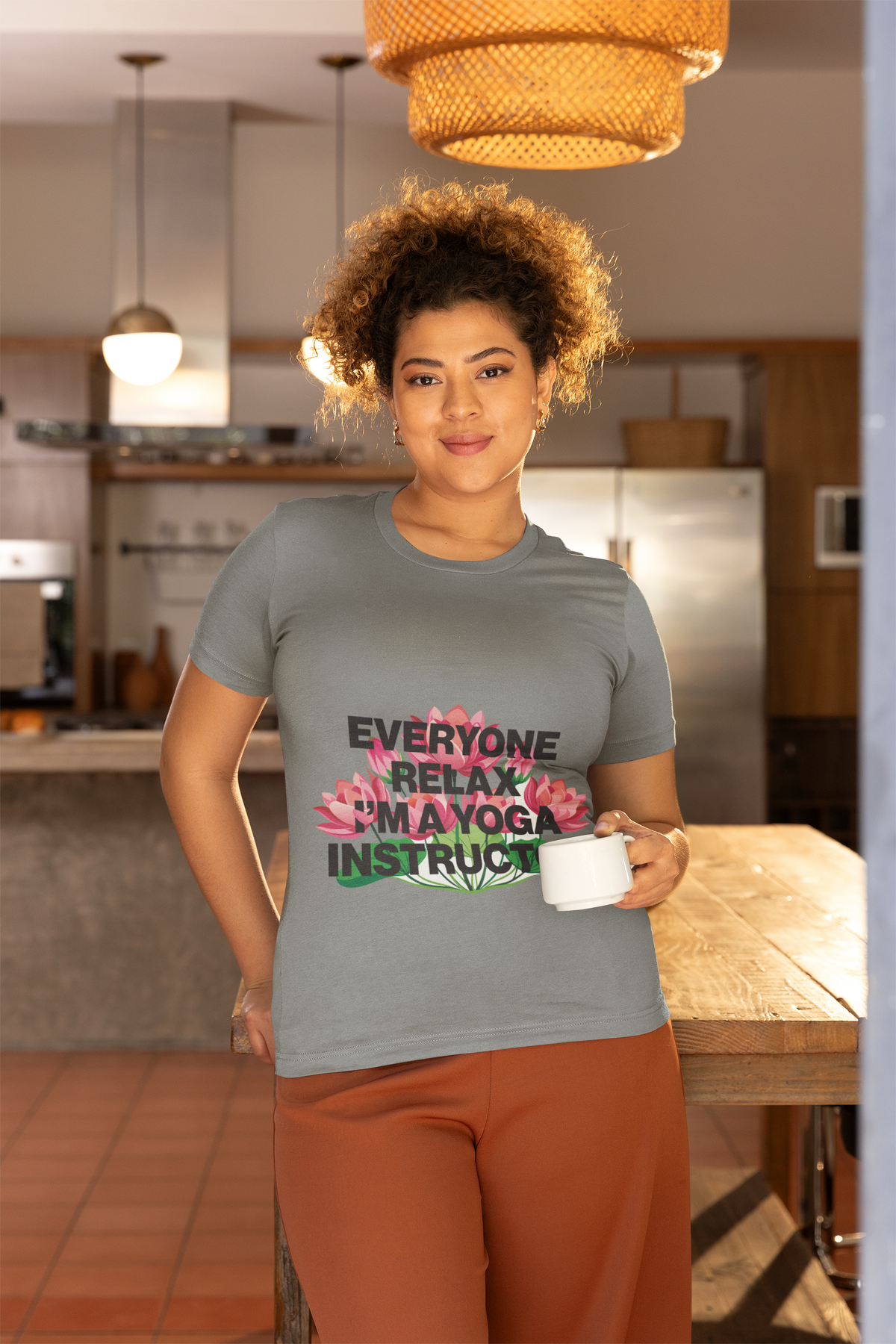 Person wearing a t-shirt with a humorous yoga instructor message in a kitchen.