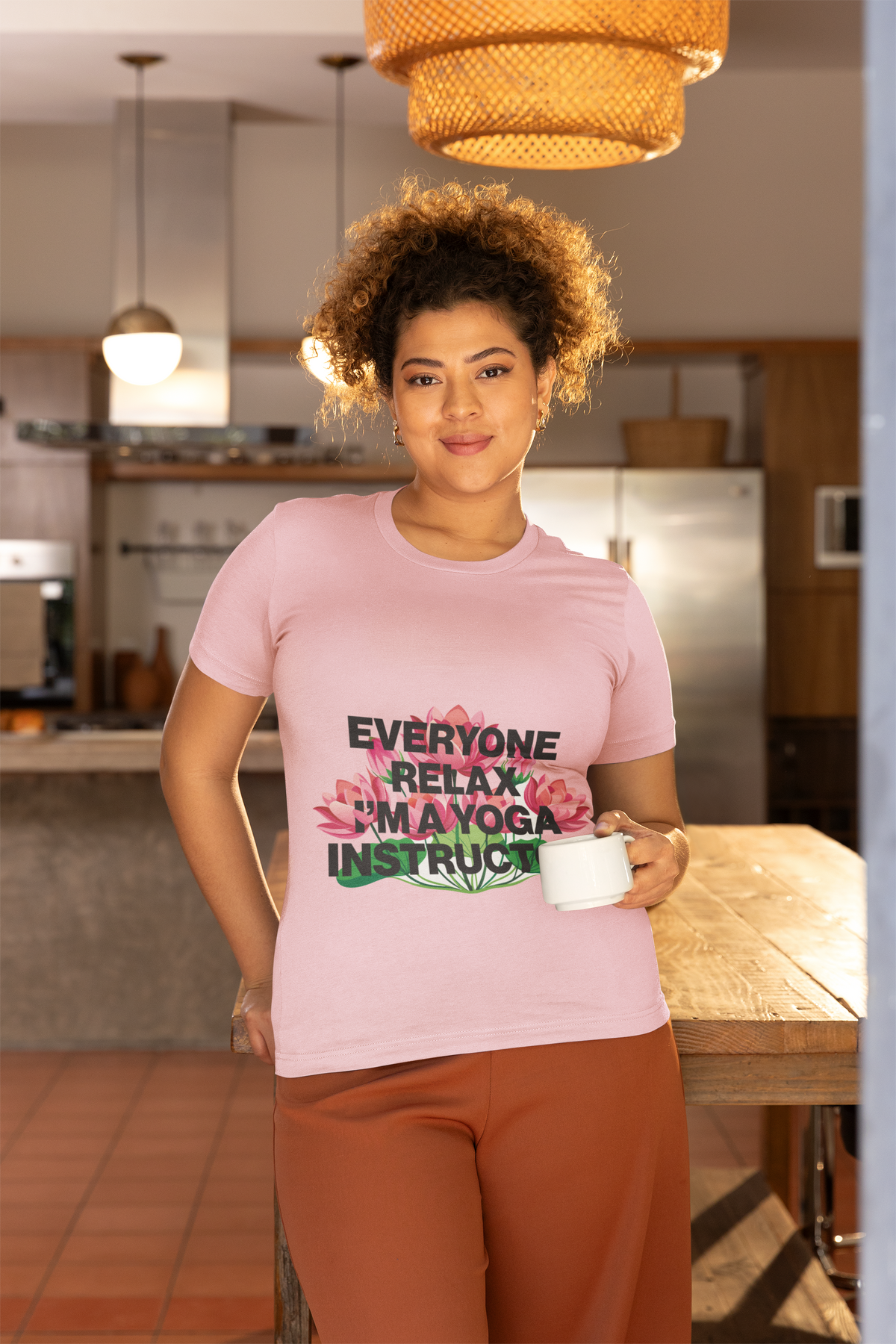 Person wearing a pink t-shirt with text in a kitchen