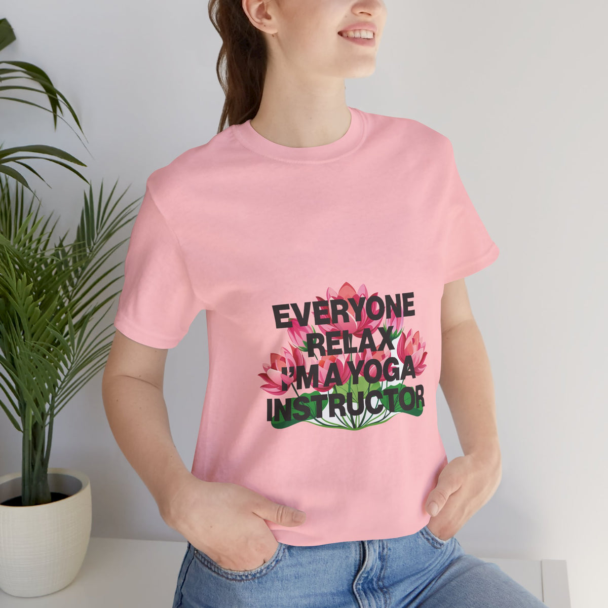 Person wearing a pink t-shirt with a humorous yoga instructor design.